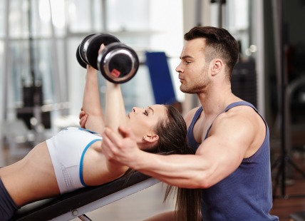 Personal trainer helping woman at gym